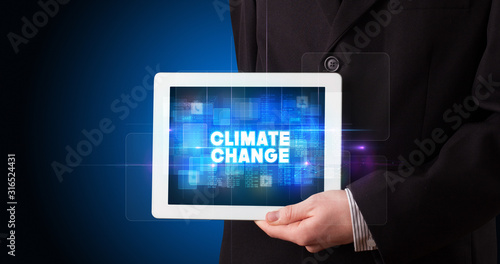 Wallpaper Mural Young business person working on tablet and shows the inscription: CLIMATE CHANGE Torontodigital.ca