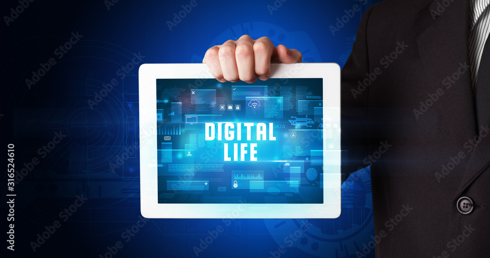 Young business person working on tablet and shows the digital sign: DIGITAL LIFE