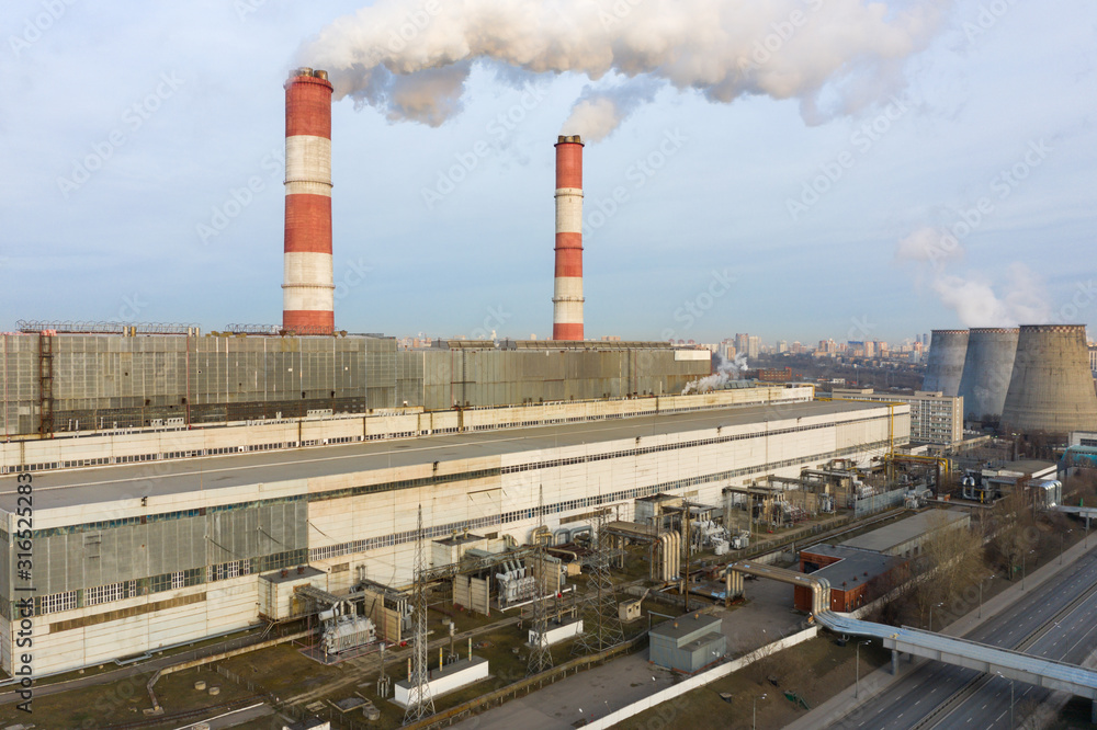 power plant pipes and cooling towers on the background of the panorama of the winter city against blue sky power plant pipes and cooling towers on the background of the panorama of the winter city against blue sky
