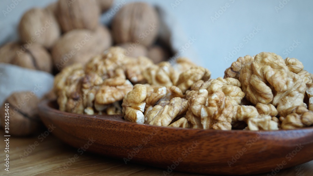 Fototapeta premium walnut kernels in a wooden dish