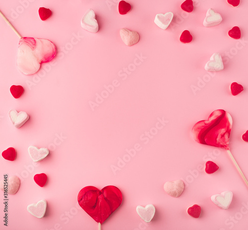 Pink romantic holiday background with with heart-shaped sweet candies. Decorative card for St. Valentine's Day with space for text.