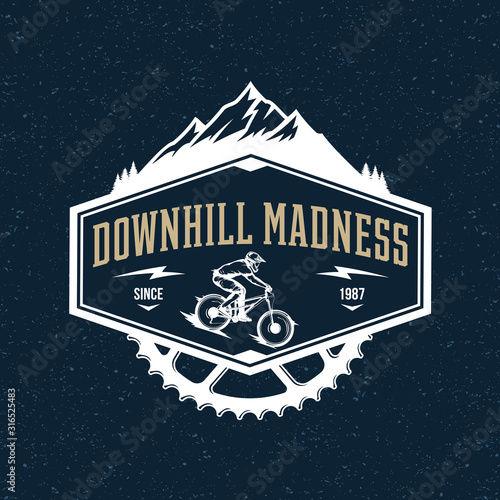 Vector downhill mountain biking badge, logo, label with rider on a bike and mountain silhouette. Downhill, enduro, cross-country biking illustration