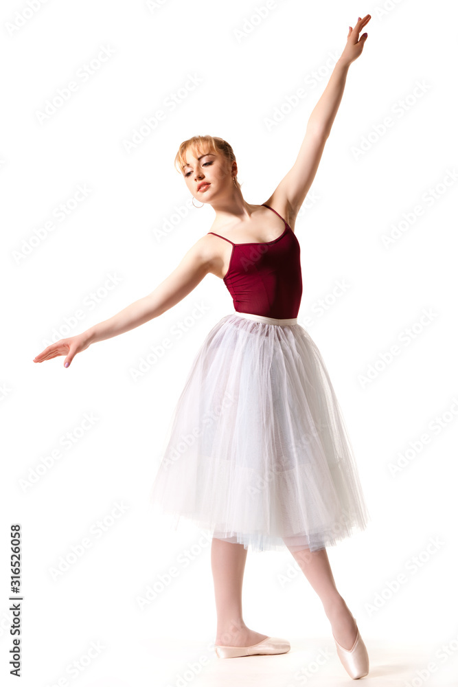 Young beautiful ballerina in white tutu and pointe shoes doing dancing pose