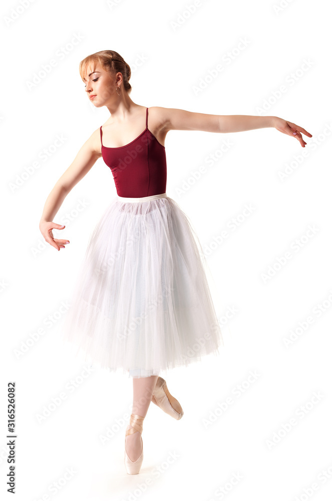 Naklejka premium Young beautiful ballerina in white tutu and pointe shoes doing dancing pose