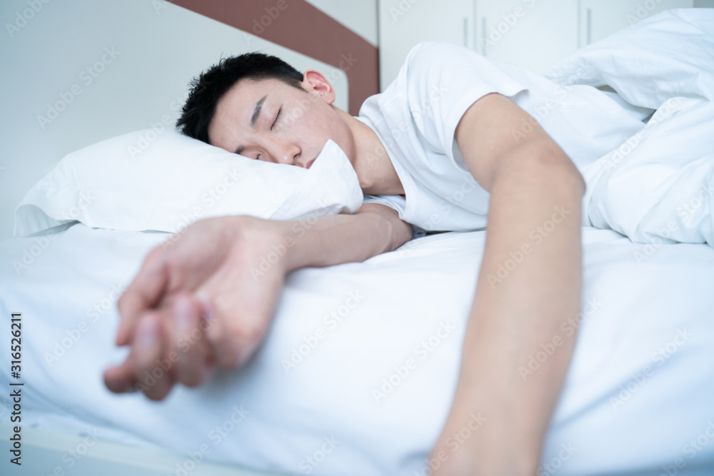 side view of bearded man sleeping on bed, lying on side side view of bearded man sleeping on bed, lying on side