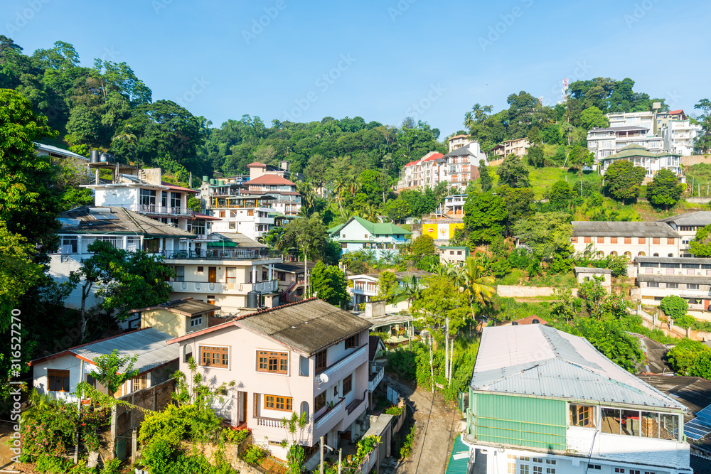 Beautiful builings on the green hills in the downtown, nex to the Kandy Lake or Kiri Muhuda or the Sea of Milk, an artificial lake in the heart of the hill city of Kandy, Sri Lanka