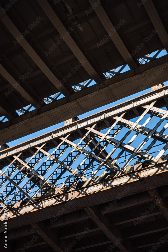 Dark and gloomy industrial atmosphere under the historical rail bridges in Manchester subway symmetry sun rays day summer blue sky