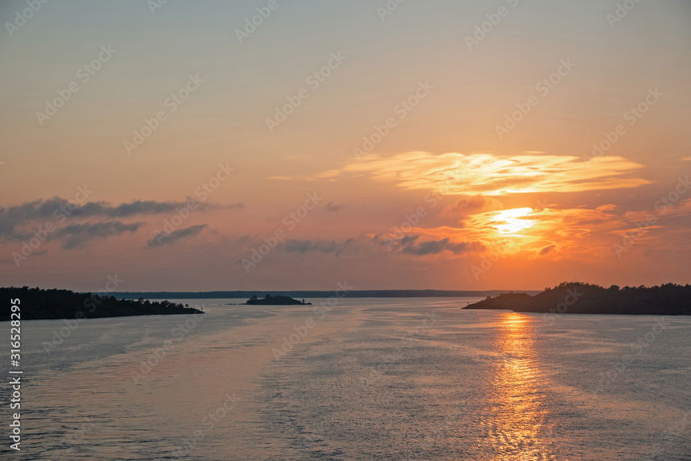 Landscape with sunset on Baltic Sea. View of waves and beautiful sunset sky with clouds from the side of the ferry.