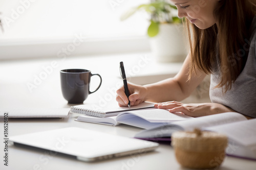 Student girl writing essay preparing for university entrance exams photo