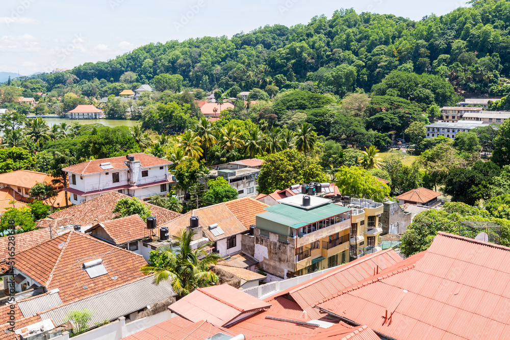 Beautiful builings on the green hills in the downtown, nex to the Kandy Lake or Kiri Muhuda or the Sea of Milk, an artificial lake in the heart of the hill city of Kandy, Sri Lanka