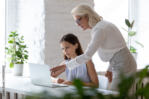 фотографія Middle-aged female boss explaining corporate application to new employee
