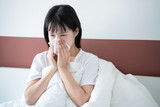 asian young woman get cold in bedroom, sneeze