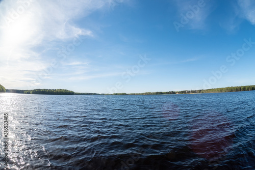 A motor boat ride on a large picturesque forest lake. Summer, Belarus, Lake Plissa