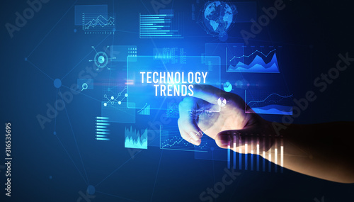 Hand touching TECHNOLOGY TRENDS inscription, new business technology concept