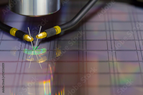 Close up of examining a sample of microchip transistor with probe station under the microscope in laboratory.A semiconductor on a silicon wafer. Selective focus. photo