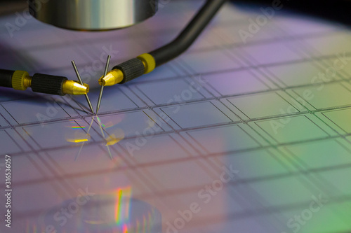 Close up of examining a sample of microchip transistor with probe station under the microscope in laboratory.A semiconductor on a silicon wafer. Selective focus.