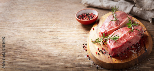 Fototapeta Naklejka Na Ścianę i Meble -  fresh meat with rosemary and spices on a wooden board