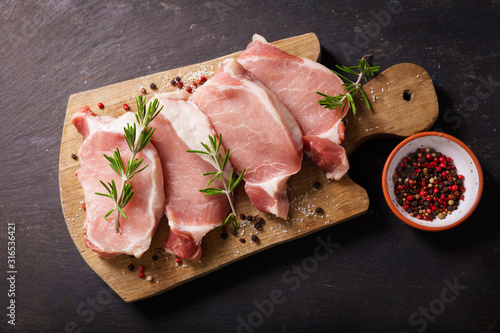 fresh pork chops with rosemary and spices, top view photo