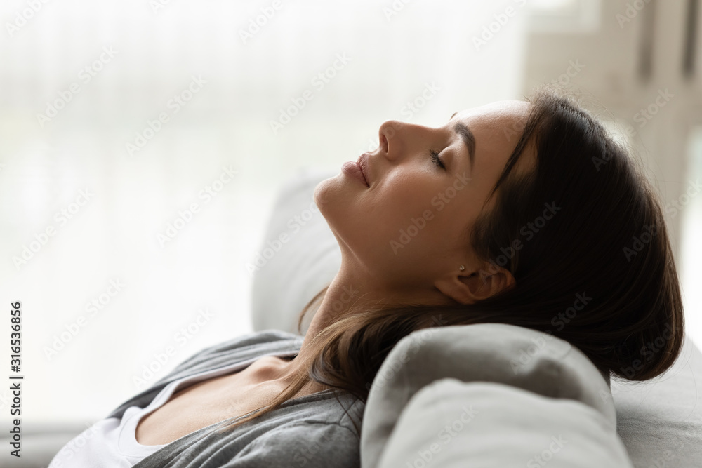 Close up peaceful beautiful woman resting on comfortable couch Close up peaceful beautiful woman resting on comfortable couch