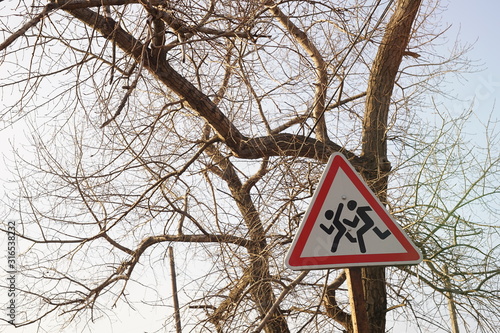 road sign caution children among dry trees