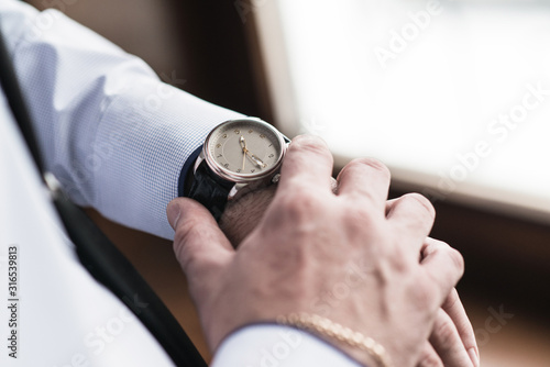 groom looks at his watch photo