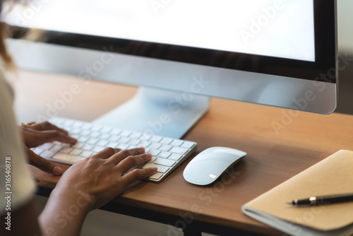 African American Woman working on Computer. Happy creative female Designer is doing graphic design at the office studio.