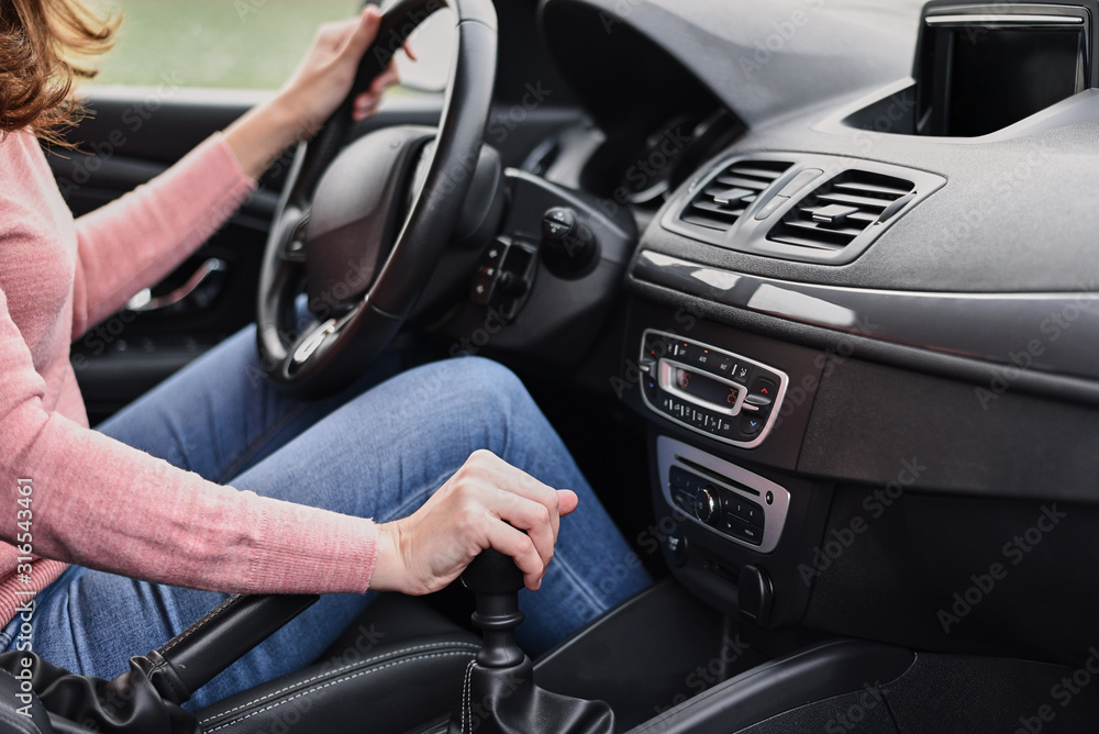 Woman driving car. Female hand change speed on the manual gearbox