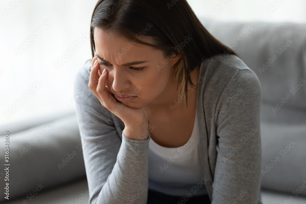 Unhappy depressed young woman thinking about problem alone close up Unhappy depressed young woman thinking about problem alone close up