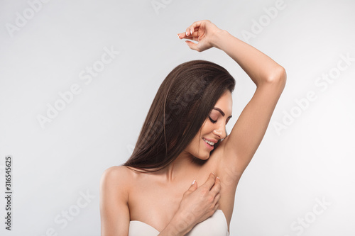 Armpit epilation, lacer hair removal. Young woman holding her arms up and showing clean underarms, depilation smooth clear skin .Beauty portrait. photo