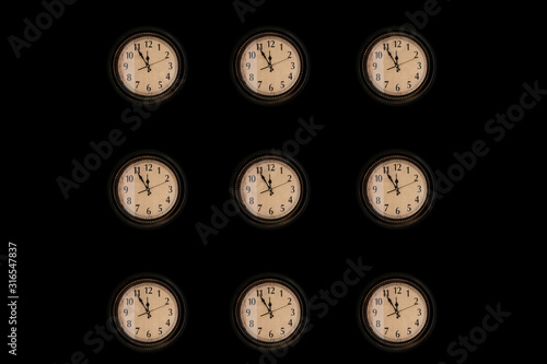 Pattern of vintage wall clocks hanging on black background.