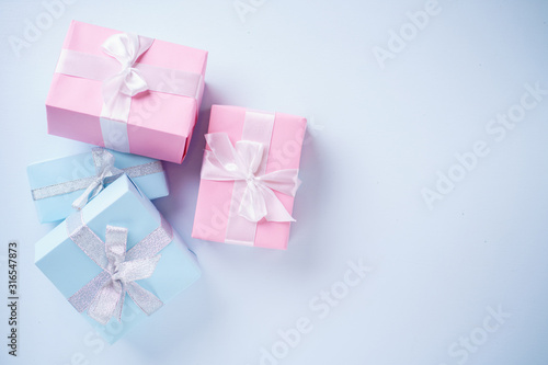 Presents, holiday traditions and shopping. Gift boxes in wrapping paper and tied with satin ribbon on blue background, copy space