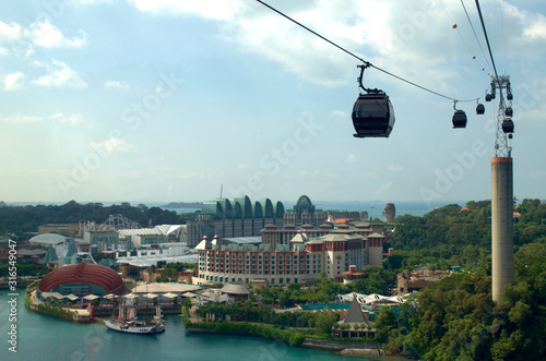 cable car in mountains with an amusement park in the background