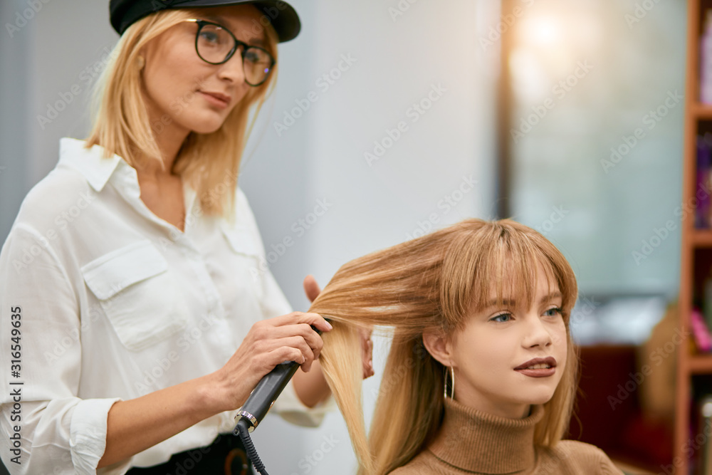 young professional hairdresser doing creative stylish hair cut in beauty saloon. styler, hairdo and client young professional hairdresser doing creative stylish hair cut in beauty saloon. styler, hairdo and client