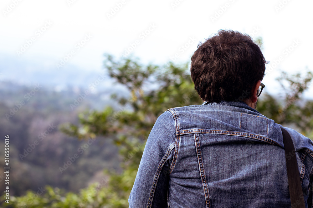 Joven de espaldas viendo el paisaje natural de la montaña Joven de espaldas viendo el paisaje natural de la montaña