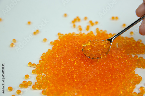 red caviar and spoon on a white background