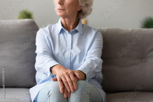 Thoughtful older woman sitting on couch, thinking about life © fizkes