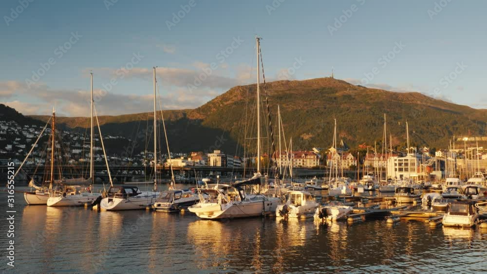 Yachts are moored in a picturesque place in the background of the mountain. The city of Bergen in Norway Yachts are moored in a picturesque place in the background of the mountain. The city of Bergen in Norway