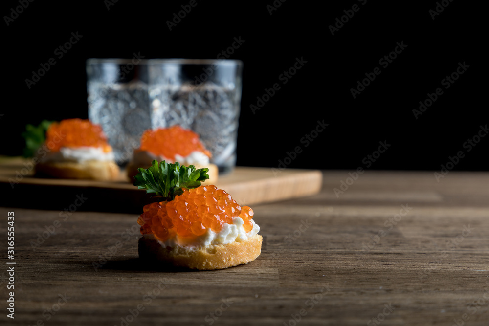 Russian Vodka, two shots of vodka with Caviar and Dark beard on black