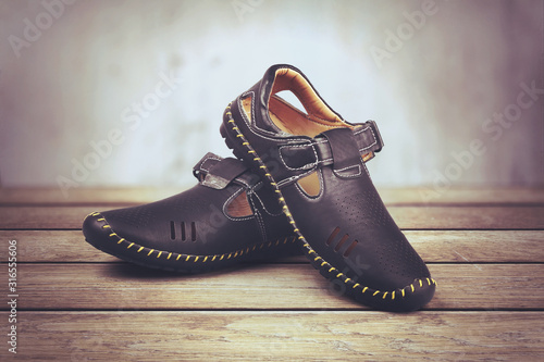Children's leather trendy shoes isolated on wooden table