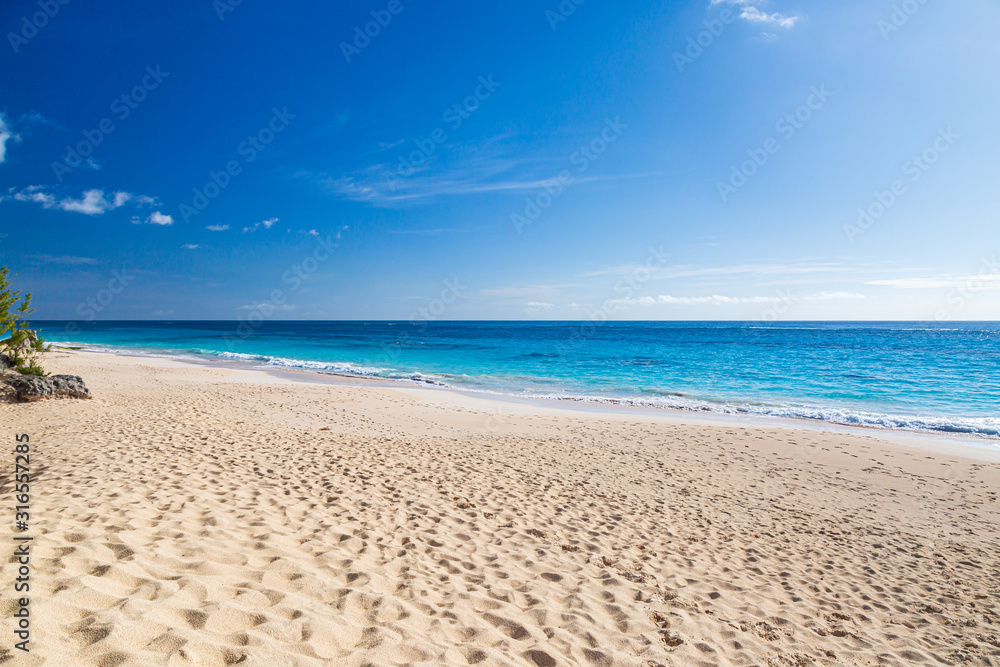 Looking along the idyllic Elbow Beach on the island of Bermuda, with a blue sky overhead Looking along the idyllic Elbow Beach on the island of Bermuda, with a blue sky overhead