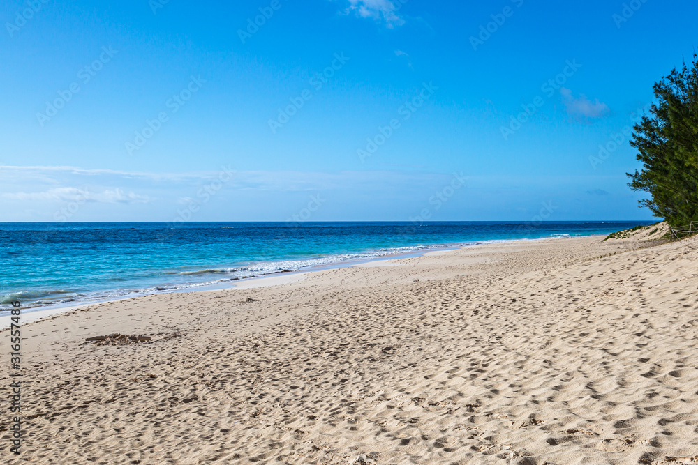 Looking along the idyllic Elbow Beach on the island of Bermuda, with a blue sky overhead Looking along the idyllic Elbow Beach on the island of Bermuda, with a blue sky overhead
