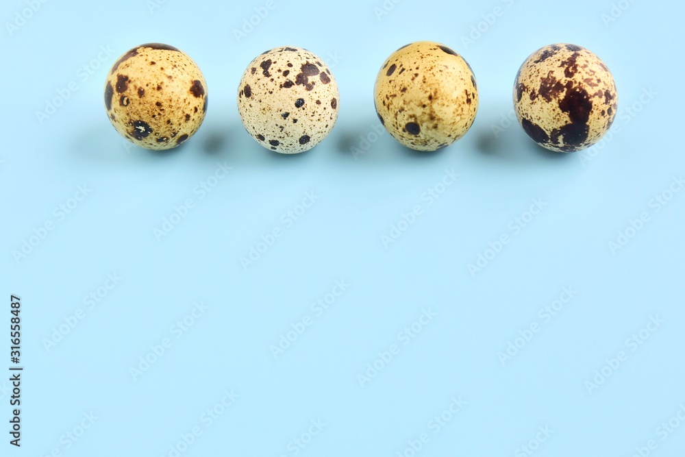 Speckled quail eggs for Easter holiday on neutral light blue background. Raw organic quail egg. Easter eggs. Ingredients for healthy protein breakfast. Keto diet. Easter background traditional symbol Speckled quail eggs for Easter holiday on neutral light blue background. Raw organic quail egg. Easter eggs. Ingredients for healthy protein breakfast. Keto diet. Easter background traditional symbol