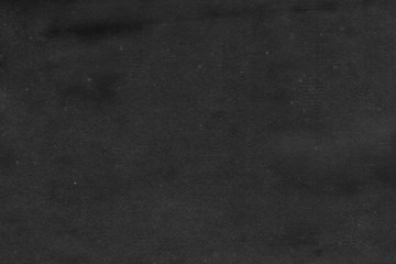 Cardboard black abstract texture close-up. Dark old paper background. Grunge concrete wall. Vintage blank wallpaper.