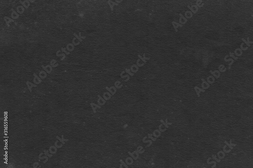 Cardboard black abstract texture close-up. Dark old paper background. Grunge concrete wall. Vintage blank wallpaper.