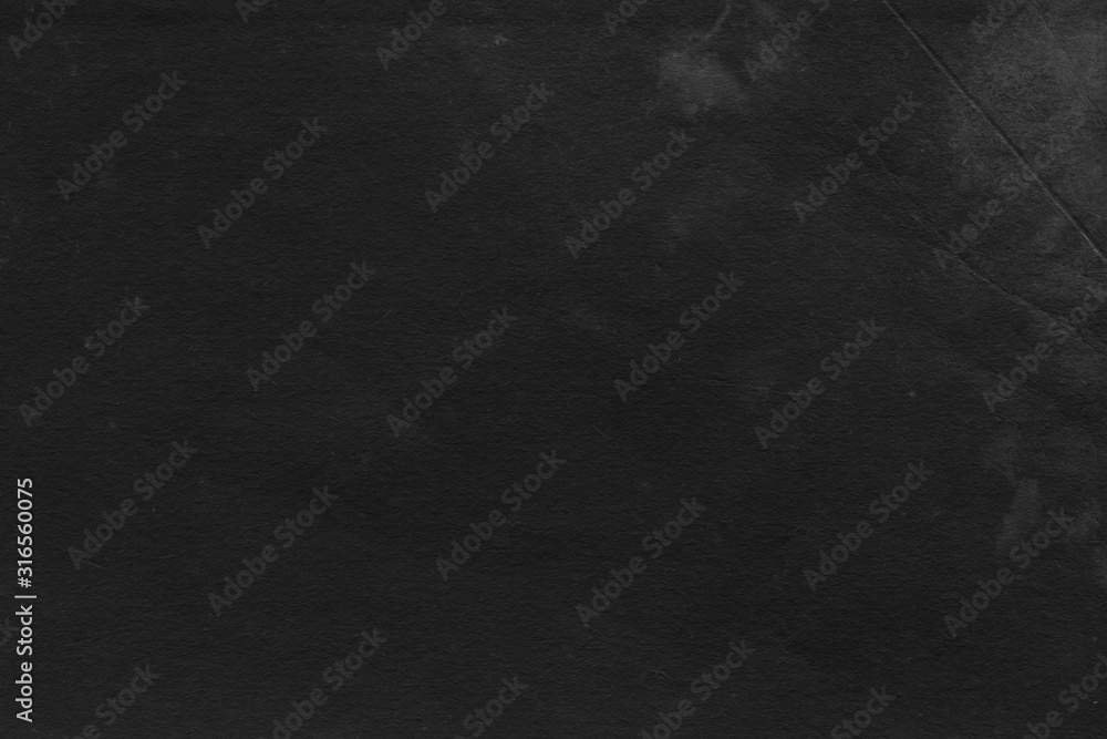 Fototapeta premium Cardboard black abstract texture close-up. Dark old paper background. Grunge concrete wall. Vintage blank wallpaper.