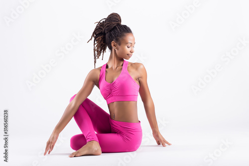 Pretty young black woman doing yoga exercise isolated on white background