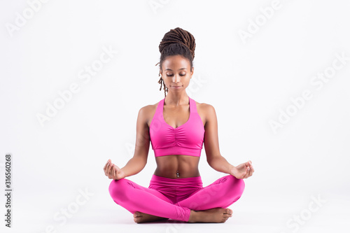 Pretty young black woman doing yoga exercise isolated on white background