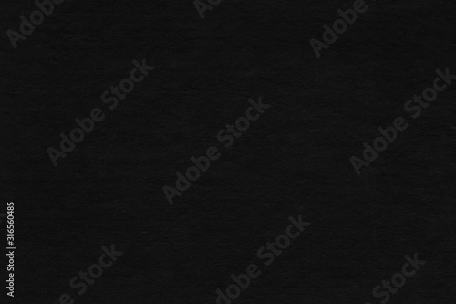 Cardboard black abstract texture close-up. Dark old paper background. Grunge concrete wall. Vintage blank wallpaper.