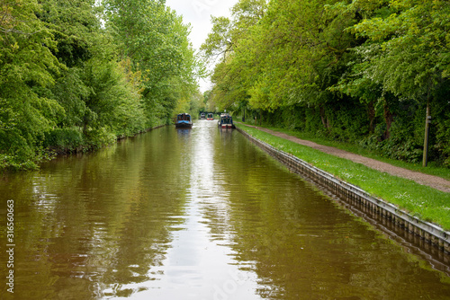 Scenic canal view with approaching narrowboat on the Llangollen Canal near Whitchurch, Shropshire, UK