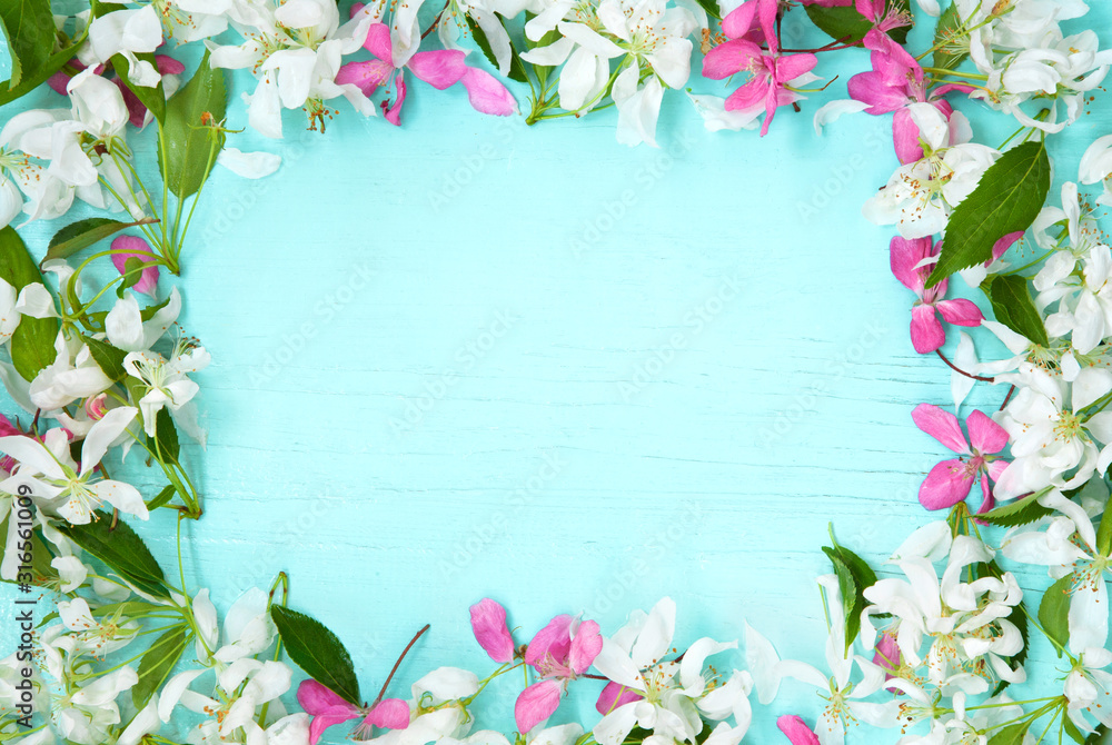 Frame of spring flowers on blue wooden background